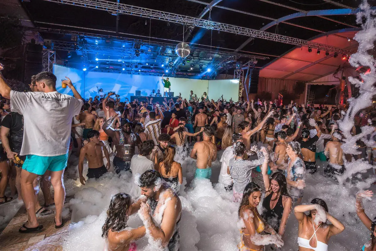Foam party at Aria Complex in Malta at night: a packed crowd dancing in front of the lit DJ stage